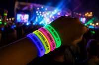Pulseras Glow personalizadas brillando en un festival nocturno Pulseras Glow personalizadas brillando en un festival nocturno